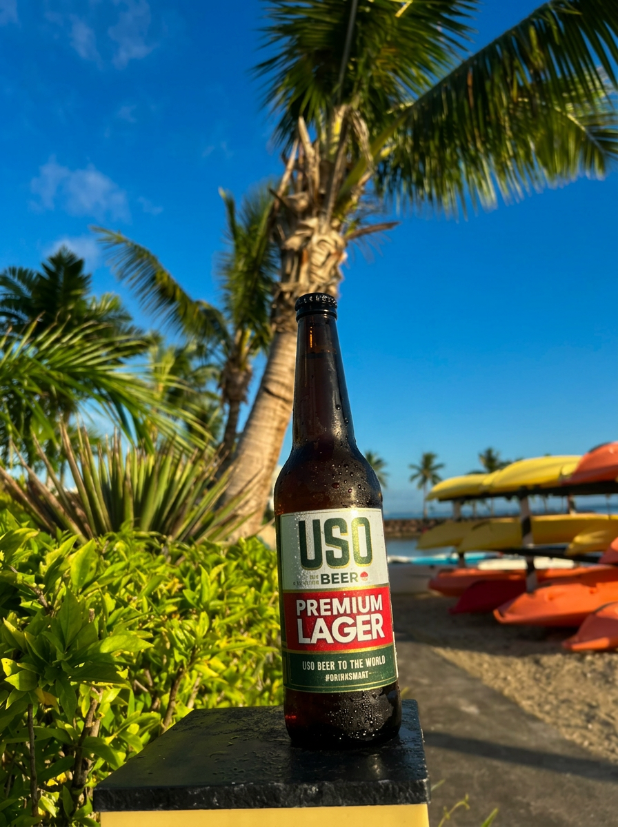 USO Premium Lager bottle by a palm tree and kayaks on the beach